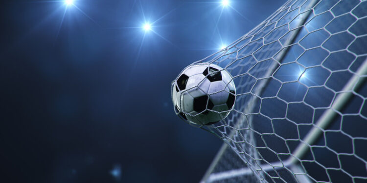 Soccer ball flew into the goal. Soccer ball bends the net, against the background of flashes of light. Soccer ball in goal net on blue background. A moment of delight, 3D illustration