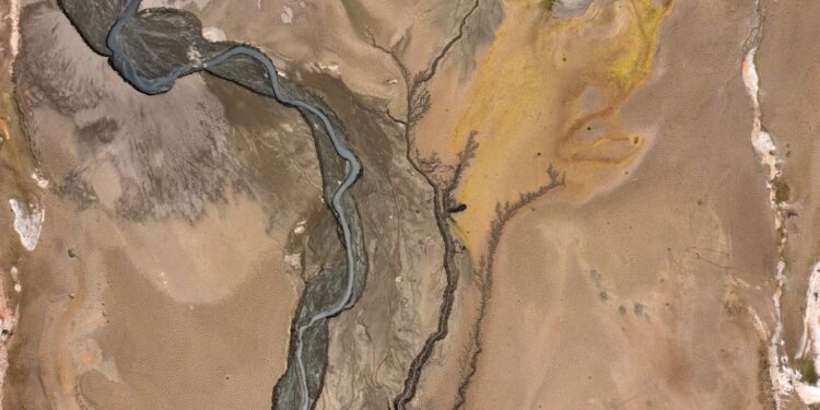 This aerial photograph shows cracks on the shore of the Mornos artificial lake following a severe drought, at the village of Kallio, about 240 km northwest of Athens, on November 3, 2025. Water levels at Lake Mornos, the primary water source for Athens, have plunged to their lowest in 15 years, raising alarms over potential water shortages in the city. Over the past three years, the reservoir has shrunk dramatically due to unusually mild winters, revealing the long-submerged village of Kallio. (Photo by Angelos TZORTZINIS / AFP)