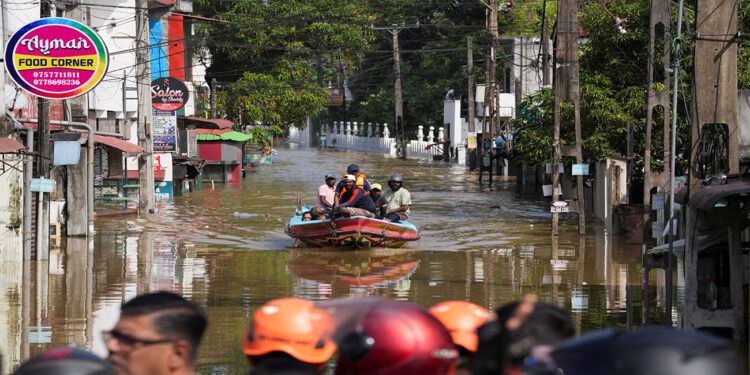 A boat carrying people moves through a flooded street, following heavy rainfall in Wellampitiya, Sri Lanka, November 30, 2025. REUTERS/Thilina Kaluthotage