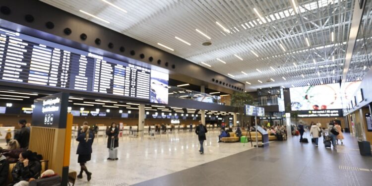 Flight passengers are pictured at a hall of the airport in Vilnius, Lithuania, on October 28, 2025. (Photo by Petras Malukas / AFP)