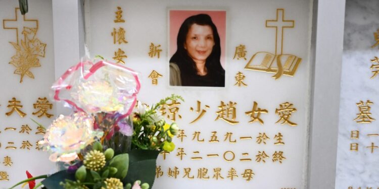 This photo taken on October 29, 2025 shows Philip Chiu placing flowers for his late sister Chiu Siu-king, who was killed in the Lamma IV ferry sinking in October 2012, at the Pok Fu Lam cemetery in Hong Kong. Survivors of one of Hong Kong's deadliest maritime disasters and victims' families who spent 13 years in a legal and bureaucratic maze seeking answers are hoping a coroner's ruling this week December 2025 will shed light on the tragedy. The Lamma IV sank in less than two minutes, killing 31 adults and eight children, becoming the city's worst maritime disaster since 1971. (Photo by Peter PARKS / AFP) / To go with AFP story Hong Kong-China-politics-law-accident, FOCUS by Holmes Chan and Anne Chan
